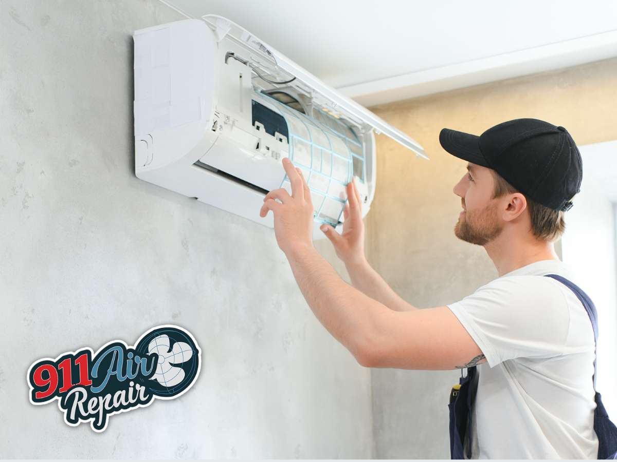 Technician performing AC unit cleaning on a wall-mounted air conditioner